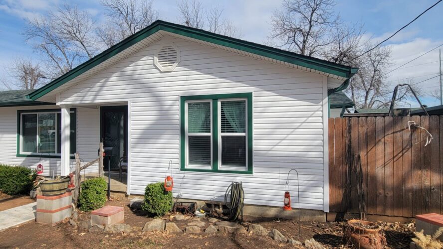Looking at a home in Burleson, Texas with white Exterior Portfolio Siding with Grecian Green Accents and new Vistamark Vinyl Windows installed by ProTex Remodeling.