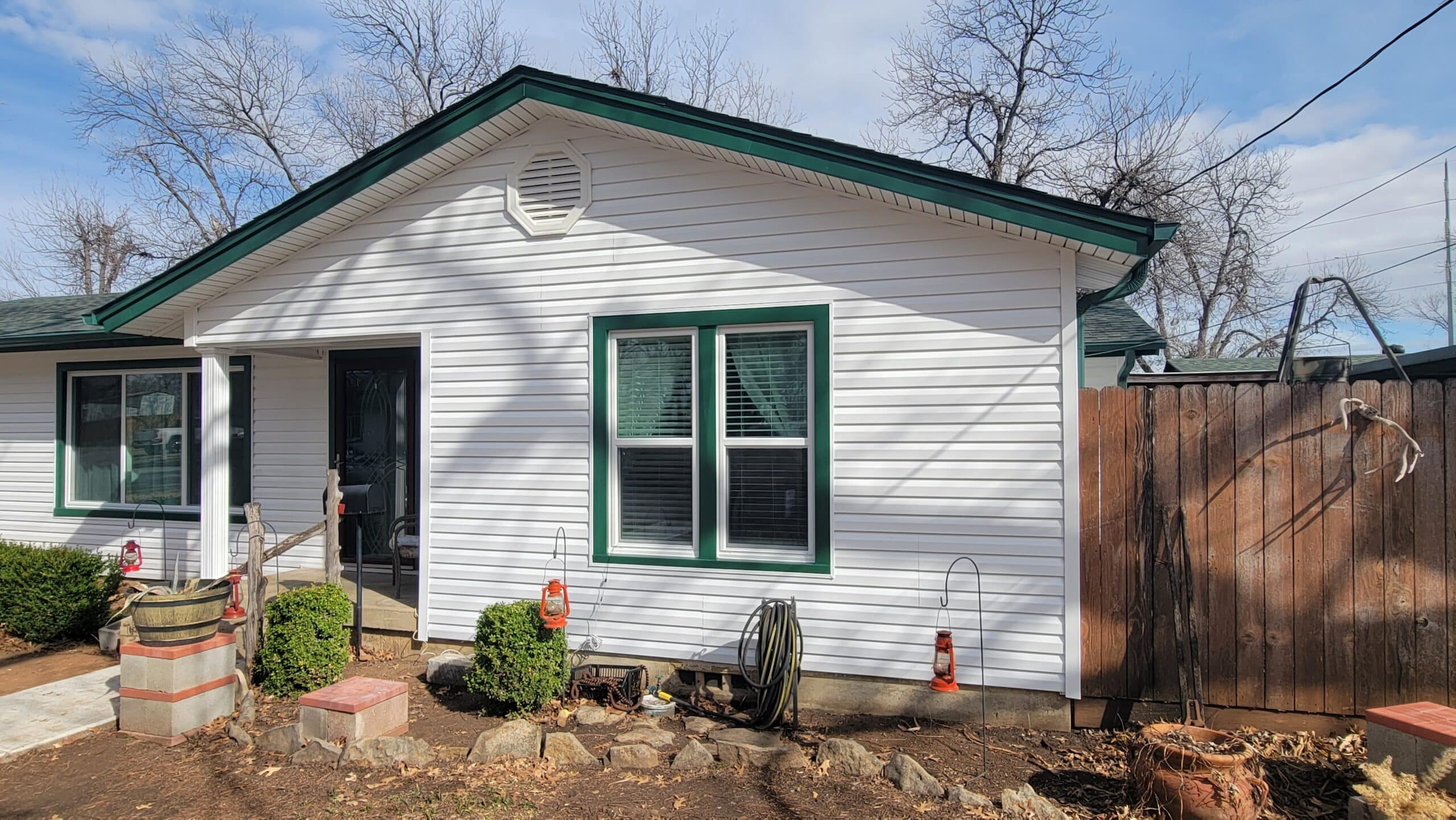 Looking at a home in Burleson Texas with white Exterior Portfolio Siding with Grecian Green Accents and new Vistamark Vinyl Windows installed.