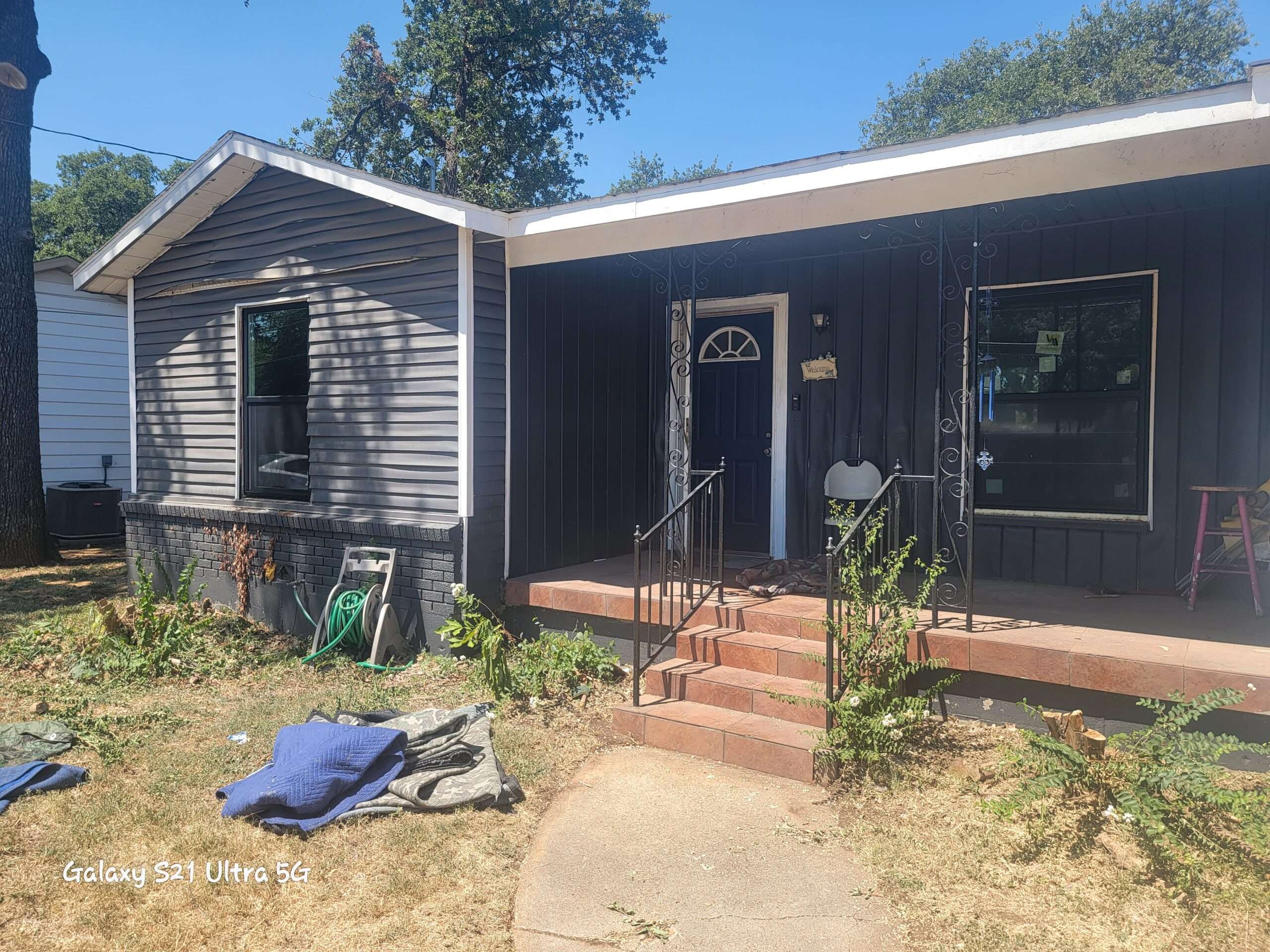 Before picture of old vinyl siding and windows that need to be replaced on a house in Hurst Texas.