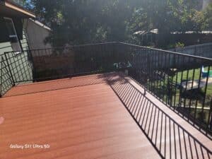 Nexan Decking finished picture. Powder coated in a light oak woodgrain finish with black safety railing.