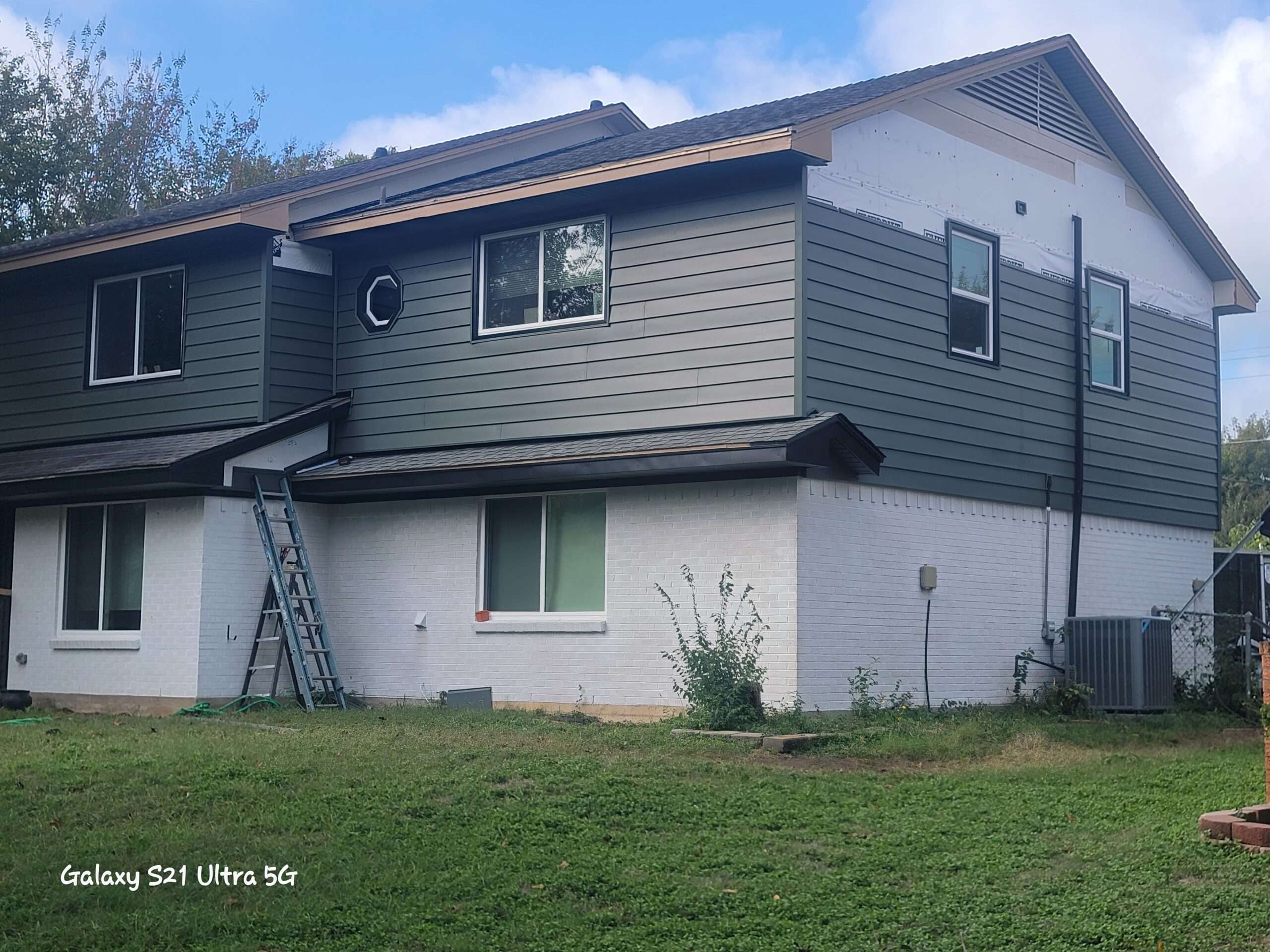 CraneBoard vinyl siding being installed in Duncanville Texas on a two story home. We also stained the brick bright white.