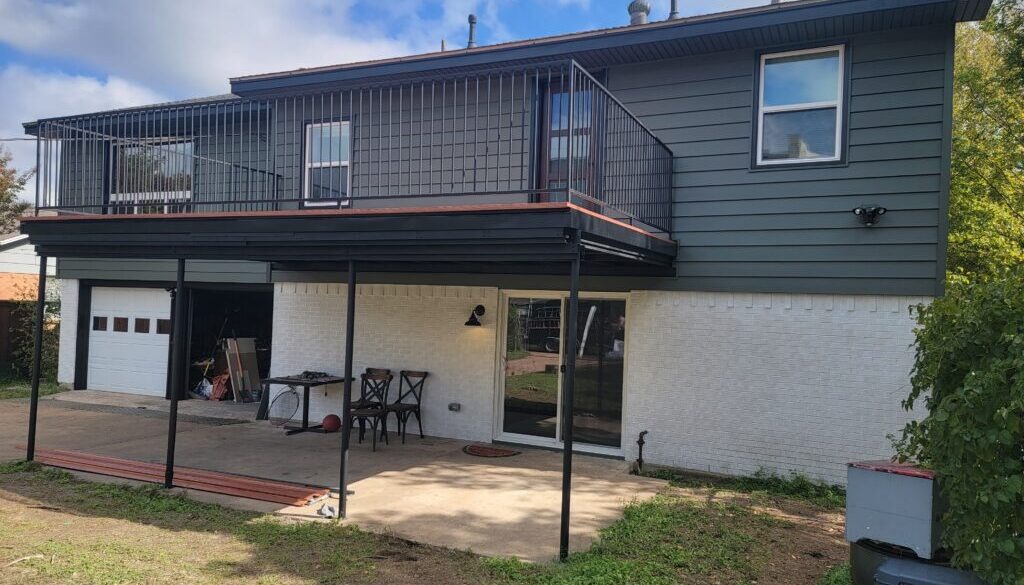 Rear view of a two story home that has new Craneboard Siding, Vistamark Vinyl Windows, Provia Doors and Nexan Lock Dry Aluminum decking.