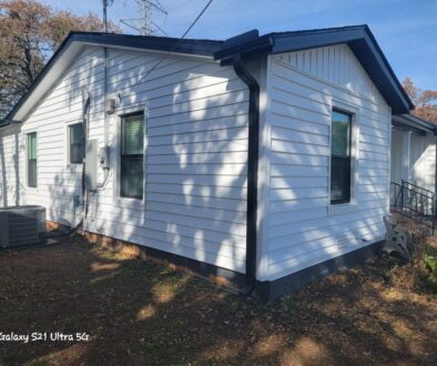 Prodigy insulated stack lap siding in dutch lap white with board and batten gables, black gutters and new vinyl windows