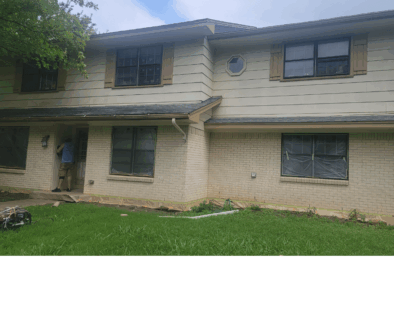 ProTex Remodeling is looking at Old Windows in a two story home that needs new replacement windows. The house has tan brick on the first floor with matching wood siding on the second floor that needs to be replaced along with the old windows. It's a bright sunny day in Texas with a light cloud cover.