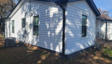 Prodigy Insulated Stack Lap Siding by ProTex Remodeling in Burleson Texas. This is a home with white lap sisng, board and batten at the gables and black accents on the soffit, fascia and gutters.